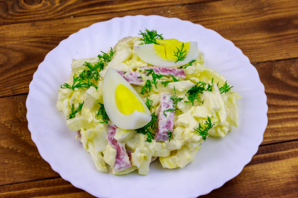 salat mit chinesischer kohl, zwiebeln, wurst, eiern und mayonnaise auf holztisch - 5944 stock-fotos und bilder