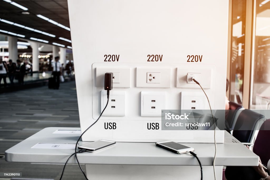 Travelers use smartphone for Charger corner free charge appliances and electronics equipment phones notebook usb / 220V socket providing tourists and travelers at Airport Thailand. Electrical Outlet Stock Photo