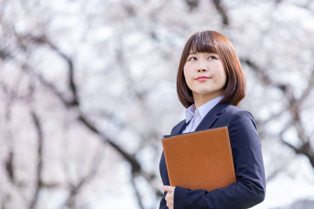 istock Woman in suit and cherry blossom 1142390166