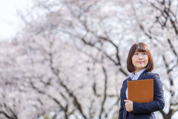 istock Woman in suit and cherry blossom 1142390168