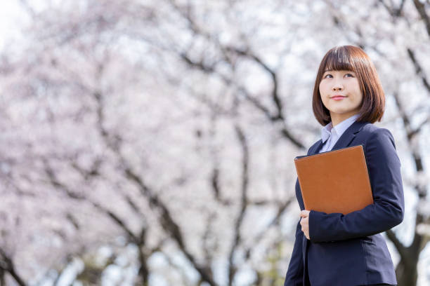 istock Woman in suit and cherry blossom 1142390169