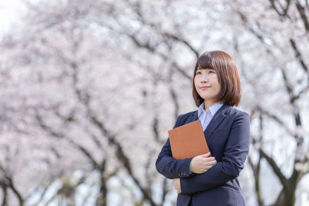 istock Woman in suit and cherry blossom 1142390194