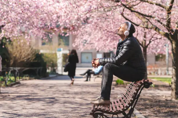 Photo of Mature man listening to music in the park