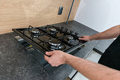 Man installing a gas hob in a kitchen