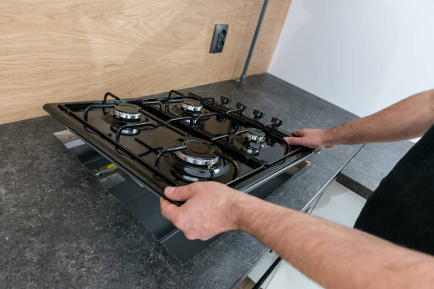 Man installing a gas hob in a kitchen Man installing a gas hob in a kitchen burner stove top photos stock pictures, royalty-free photos & images
