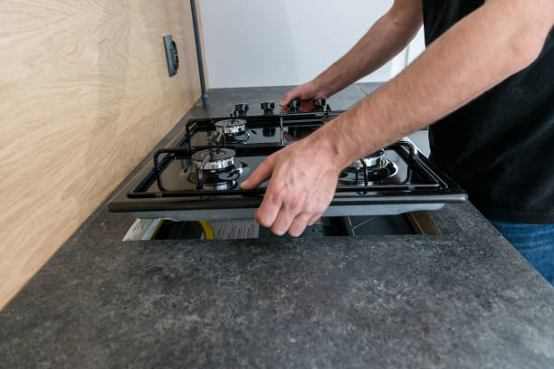 Man installing a gas hob in a kitchen Man installing a gas hob in a kitchen gas stove burner photos stock pictures, royalty-free photos & images