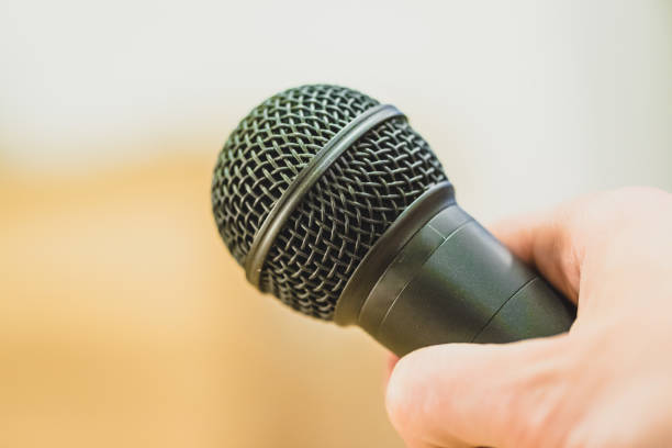 istock Interview: Journalist is holding a microphone in his hand. Close up. 1142395866