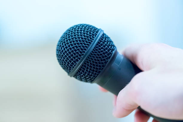 istock Interview: Journalist is holding a microphone in his hand. Close up. 1142395889