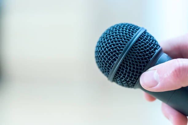 istock Interview: Journalist is holding a microphone in his hand. Close up. 1142395987