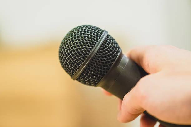 istock Interview: Journalist is holding a microphone in his hand. Close up. 1142395988