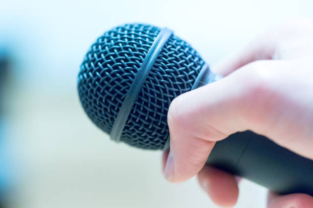 istock Interview: Journalist is holding a microphone in his hand. Close up. 1142395995