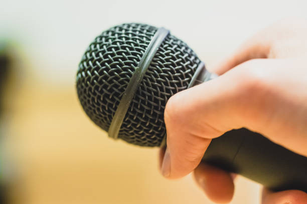 istock Interview: Journalist is holding a microphone in his hand. Close up. 1142396006