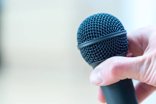 istock Interview: Journalist is holding a microphone in his hand. Close up. 1142396032