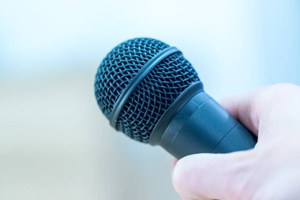 istock Interview: Journalist is holding a microphone in his hand. Close up. 1142396078