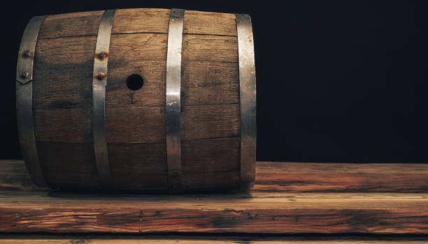 istock Wooden barrel on a old oak table. Black background behind. 1142401072