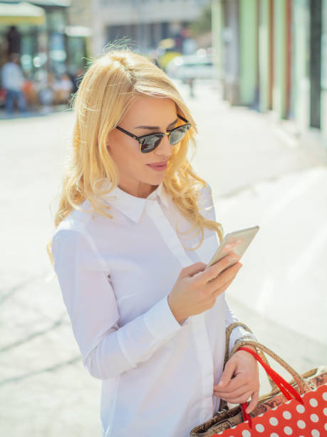 istock Beautiful young woman using smartphone 1142401296