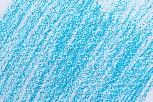 Close-up of a blue colored scribble with wax colored crayon on a white sheet of paper