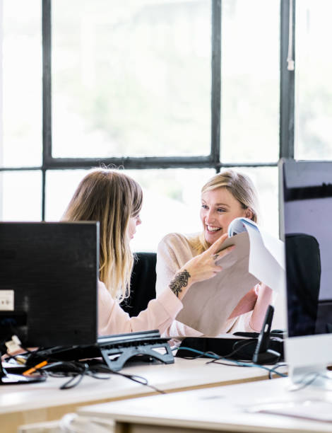 istock Happy businesswomen discussing over documents 1142403749
