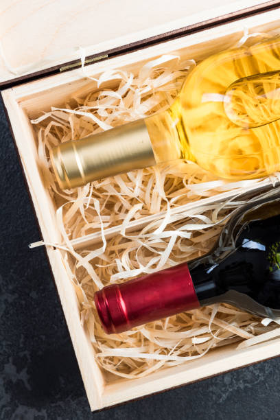 istock Red and white wine bottles in vintage wooden box 1142404708