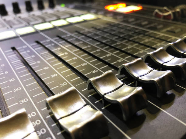 istock Close up professional digital audio mixing console with faders and adjusting knobs. Angle view. 1142405880
