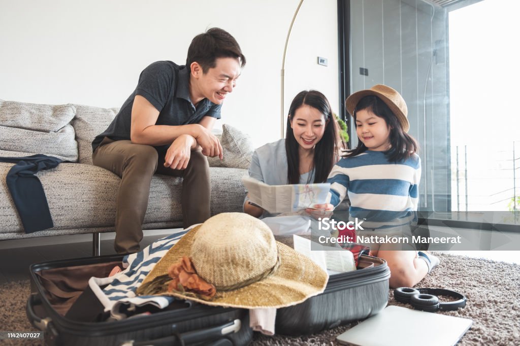 Asian family packing bag/luggage and planning to travel on summer vacation Family Stock Photo