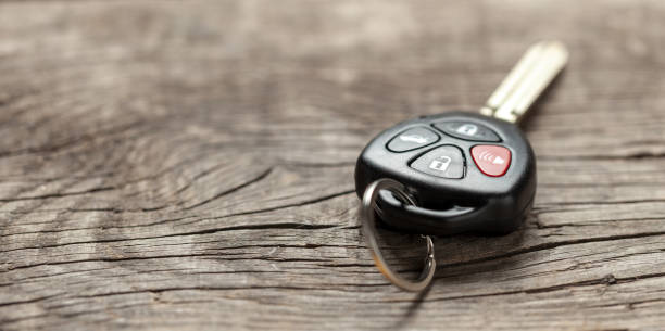 istock Car keys with remote control alarms on wooden background. Copy space for text. 1142408838