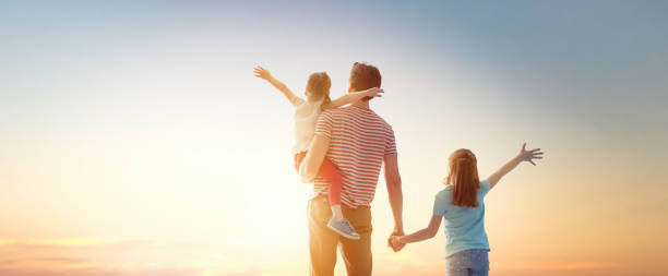 istock happy family at sunset. 1142409577