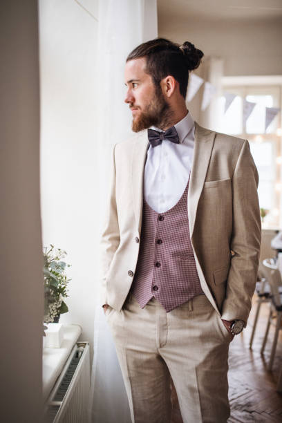 istock A handsome hipster young man with formal suit standing on an indoor party. 1142413343