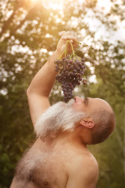 istock Bacchus eating grapes outdoors 1142415156