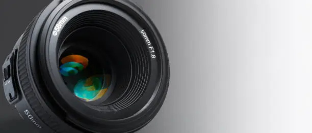 Photo of A modern photographic lens with a 50mm focal length on a white background