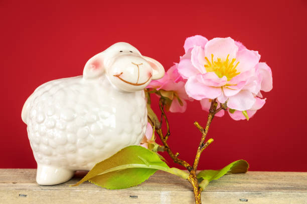 In a cozy hotel room, a soft plush sheep rests serenely on a crisp white bedsheet, embodying comfort and charm. The room exudes a tranquil atmosphere, perfect for relaxation after a day of travel or exploration. The plush toy, with its fluffy wool and gentle demeanor, adds a touch of whimsy and warmth to the neatly arranged bedding. Set against a backdrop of muted décor and soft lighting, the scene invites a sense of peaceful retreat, where the plush sheep becomes a delightful companion in this serene setting.