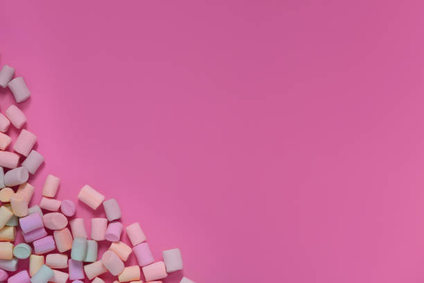 istock Isolated multicolored marshmallows scattered in the corner on a pink background. Banner, postcard. Top view, copy space. 1142424050