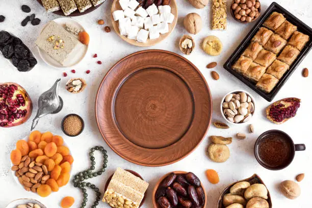 Assortment, set of Eastern, Arabic, Turkish sweets, nuts and dried fruits around plate, top view, copy space. Holiday Middle Eastern traditional sweet food.