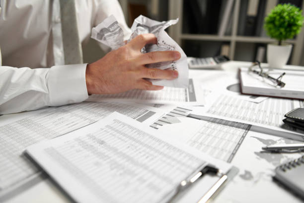 istock Angry businessman has stress and troubles with bad reports, he breaks documents and throws it. 1142424584