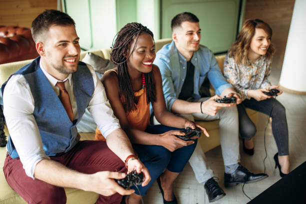 Group of young entrepreneurs having fun playing video games in their business office