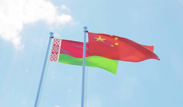 istock Belarus and China, two flags waving against blue sky 1142425770