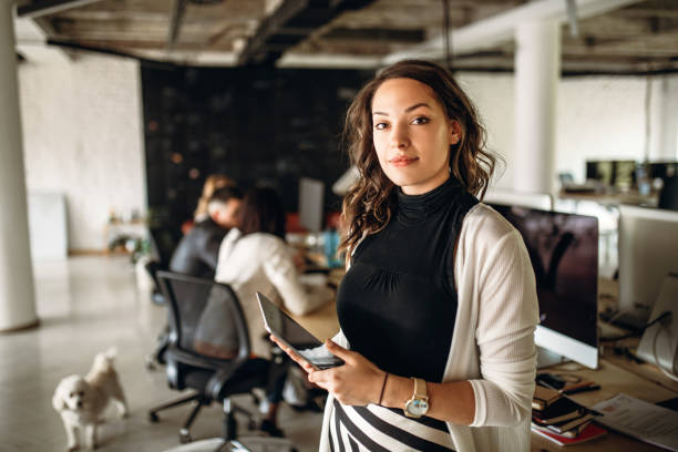 Photo of young business woman in the office Portrait of a young business woman in the modern office, and a team behind her millennial generation stock pictures, royalty-free photos & images