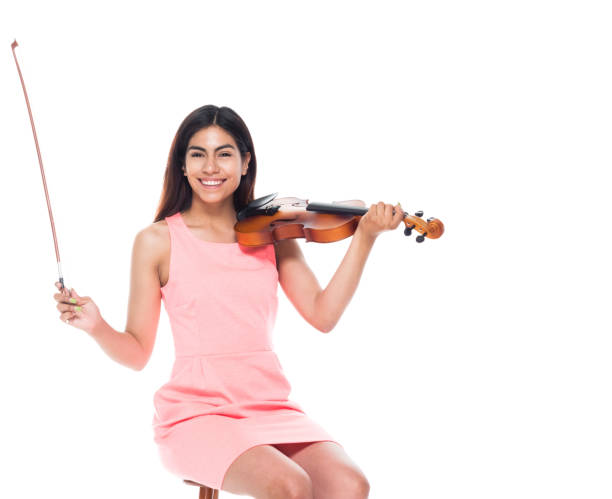 istock Attractive young latino female playing the violin while sitting on stool 1142428602