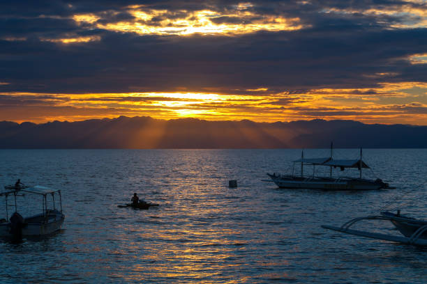 Man rowing a boat of Siquijor Man rowing a boat of Siquijor, Philippines siquijor island stock pictures, royalty-free photos & images