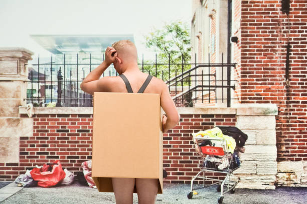 istock Poverty man in box shirtless looking away 1142430317