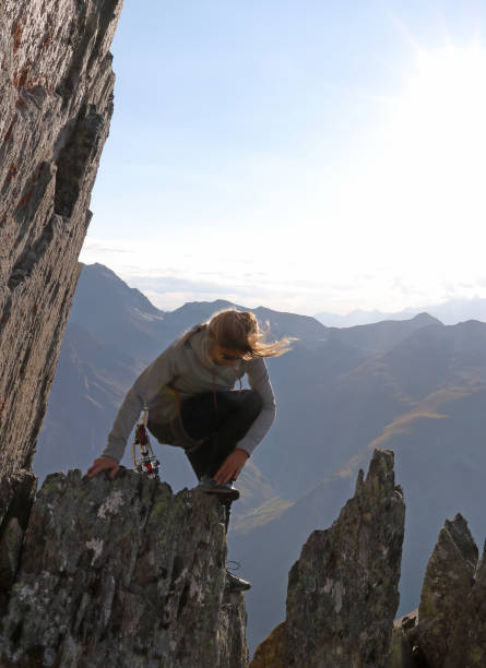 istock Young woman scrambles on rock pinnacles in mountains 1142431209