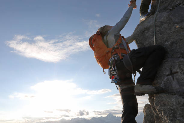 Man using rope to climb the mountain, view from above