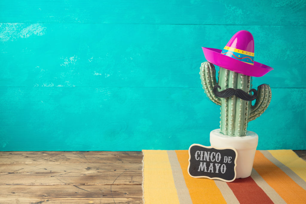 Cinco de Mayo holiday background with Mexican cactus and  party sombrero hat on wooden table