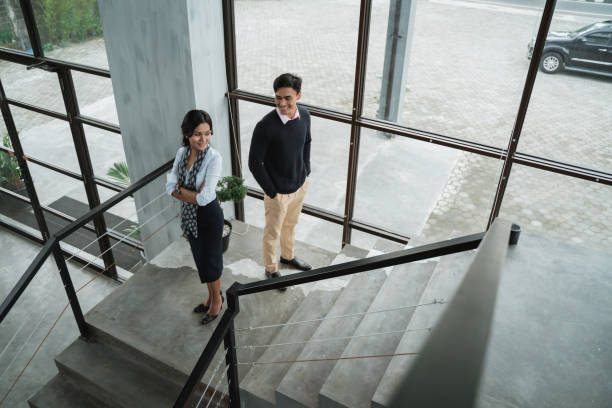 istock business people smile standing on the stairs with folded hands 1142435288