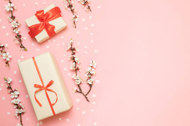 istock Gift boxes with red ribbons, flower branches 1142436278