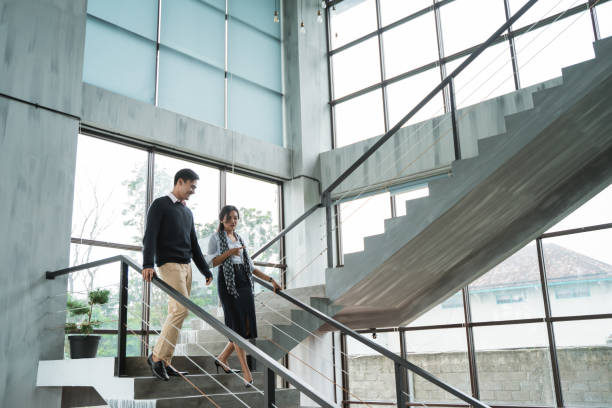 geschäftspartner gehen mit dem chatten auf der treppe hinunter - staircase walking office steps stock-fotos und bilder