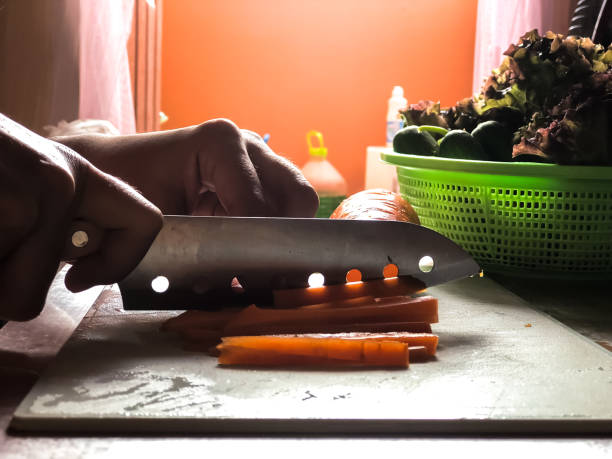 Woman cooking salad,human hands chopping vegetable,vegetarian,carrot,cucumber and red coral lettuce ,home cooking,healthy concept,Preparation of food,Silhouette style