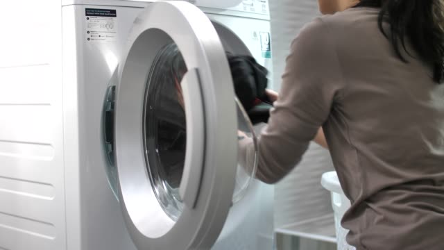 Woman doing the laundry with Washing Machine at home