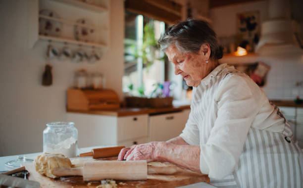 istock Elderly woman making cakes in a kitchen at home. Copy space. 1142441280