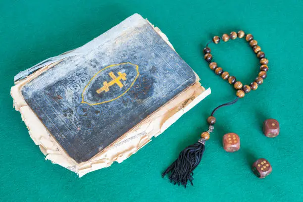 Photo of old psalm book, worry beads and three wooden dices